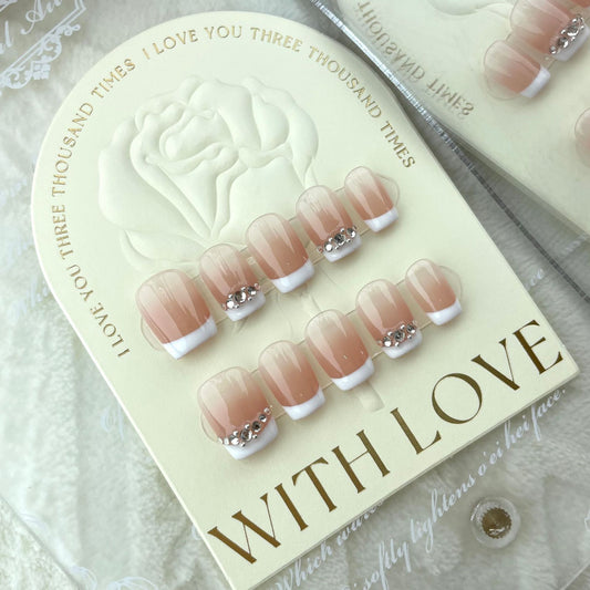 ongles nude couleur clair et blanc avec strass gris simple